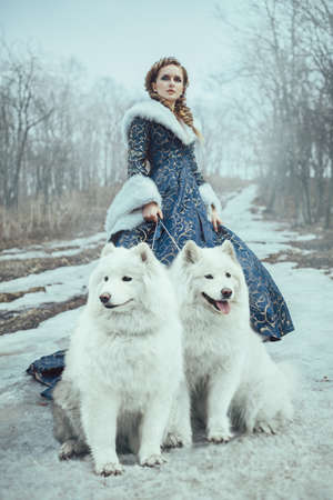The woman on winter walk with a dogの写真素材