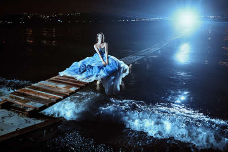 Beautiful lady in blue dress walking near sea