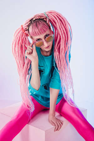 Modern teenage girl with pink dreadlocks on white backgroundの写真素材