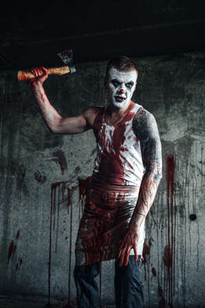 Crazy clown holding an ax in his handsの写真素材