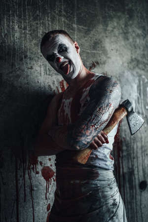 Crazy clown holding an ax in his handsの写真素材