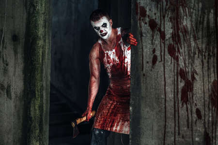 Crazy clown holding an ax in his handsの写真素材