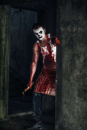 Crazy clown holding an ax in his handsの写真素材