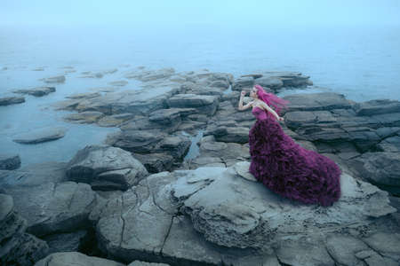 Woman near foggy seaの写真素材