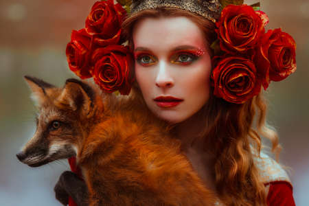 A young woman in medieval red dress with a foxの写真素材