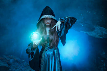 The witch with magic ball in her hands causes a spiritsの写真素材