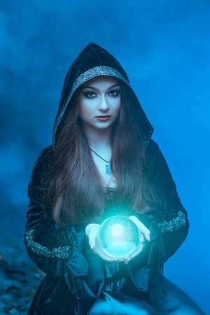 The witch with magic ball in her hands causes a spiritsの写真素材
