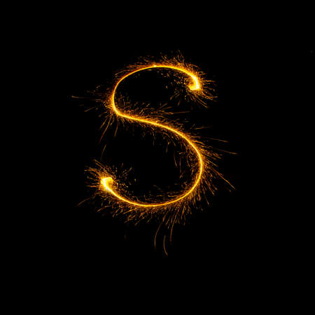 Alphabet sparklers on black background single letterの写真素材