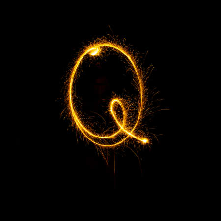 Alphabet sparklers on black background single letterの写真素材
