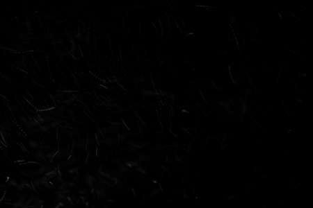 Abstract real dust floating over black backgroundの写真素材