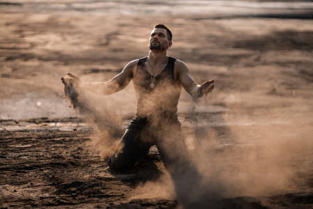 Attractive tanned man on the black sandの写真素材