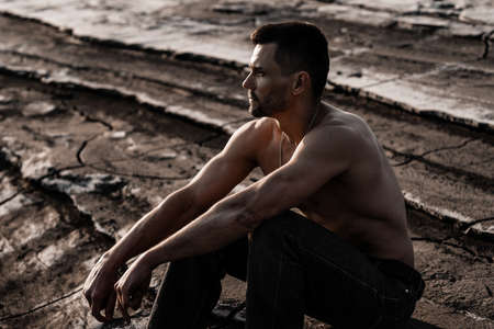 Attractive tanned man on the black sand