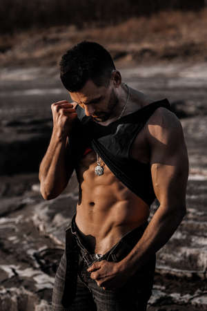 Attractive tanned man on the black sand