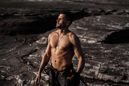 Attractive tanned man on the black sandの写真素材