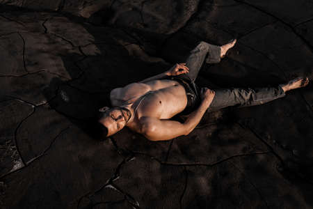 Attractive tanned man on the black sandの写真素材