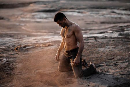 Attractive tanned man on the black sand