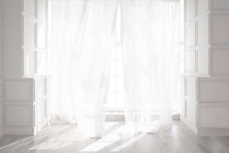 Backlit window with white curtains in empty room