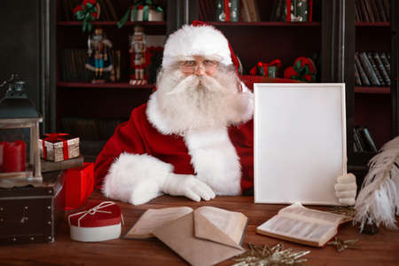 Santa Claus holding white frame in his handsの写真素材