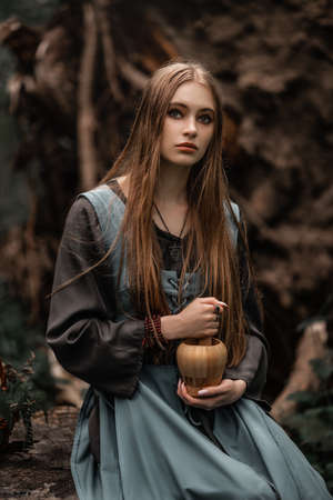 A mysterious witch walks in a dark forest