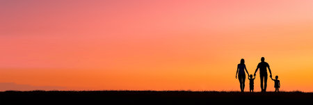 Family walks hand in hand at duskの素材