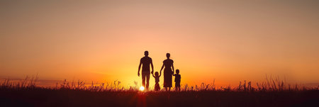 Four family members walking in the sunsetの素材