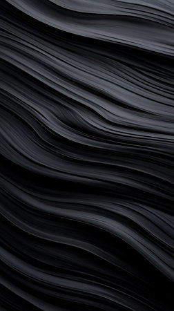 Smooth black waves create a striking abstract texture in a dark settingの素材