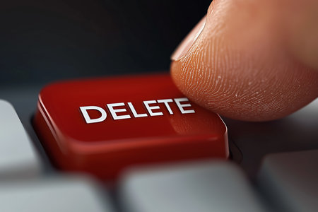 Finger pressing delete key on keyboard to remove unwanted content during digital activityの素材