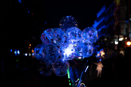 Transparent balloons with blue LED lights glowing in the dark at a light festival, creating a magical and colorful night atmosphere.の写真素材
