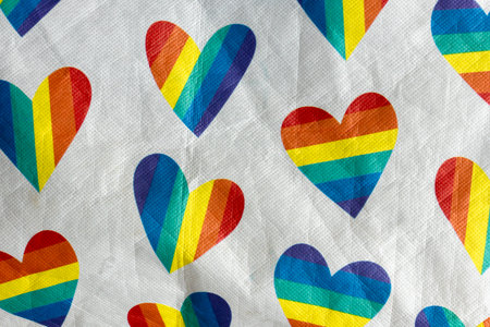 Colorful rainbow hearts printed on fabric, symbolizing love, diversity, and LGBTQ pride, with soft...