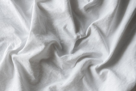 White fabric background with soft wavy folds and gentle texture, ideal for minimalist design,...