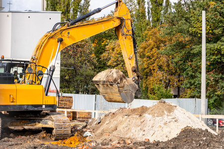 Excavator loading soil into a dump truck at a construction site under daylight conditions.