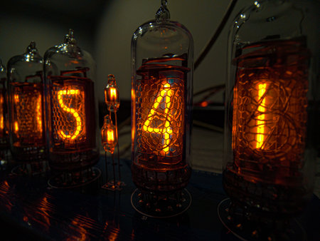 Close-up of a glowing IN-14 nixie tube clock, showcasing vintage electronics and intricate details in warm light.の写真素材