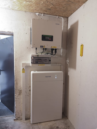 Wall mounted inverter with electrical panel and battery storage system, showing modern energy management equipment for power conversion and storage.のeditorial素材