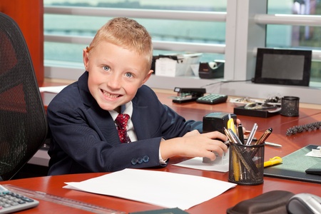 Cute Young Boy in Business Office with Funny Expressionの写真素材