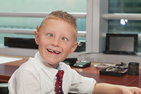 Cute Young Boy in Business Office with Funny Expressionの写真素材