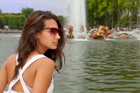 Beautiful young woman enjoying a Parisian fountainの写真素材