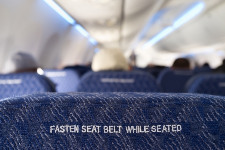 Fasten seat belt sign on the back of a seat from a commercial airliner の写真素材