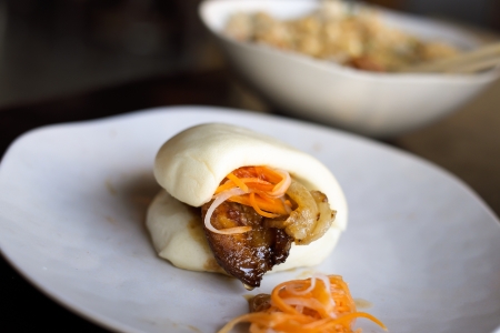 Close up view of a pork man tau bun with a bowl of fried rice.の写真素材