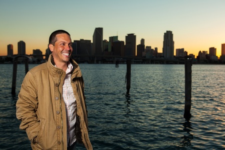Handsome young Hispanic man outdoor portrait with city skyline in the background at sunset の写真素材