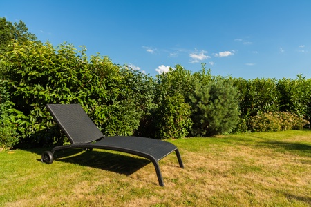 Wicker lawn chairs in a back yard residence の写真素材