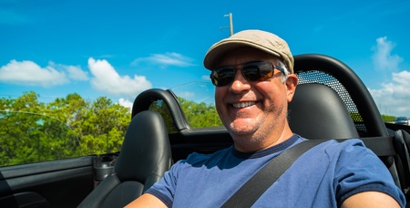 Handsome middle age man driving a convertible automobile on the highway の写真素材