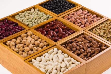 Collection of various beans contained in wood boxes on a white background の写真素材