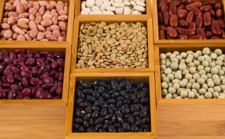 Collection of various beans contained in wood boxes on a white background の写真素材