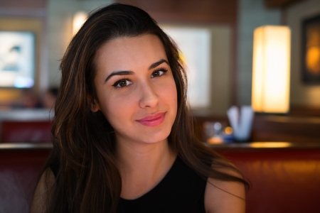 Beautiful multicultural young woman in a restaurantの写真素材