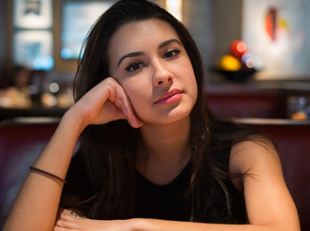 Beautiful multicultural young woman portrait in a restaurant setting の写真素材