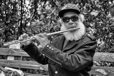 SAVANNAH, GEORGIA OCTOBER 8  An unidentified African American street performer playing classical style music on the flute in a square in historical Savannah on October 8, 2013 のeditorial素材