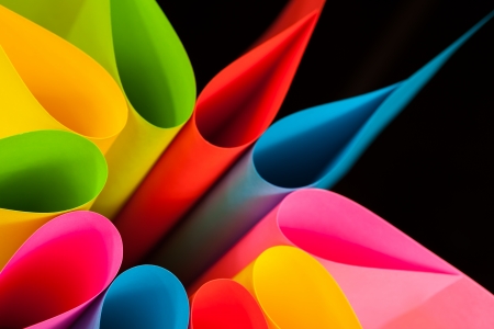 Colorful card stock in unique elliptical shapes with shadow effect and selective focus on a black background の写真素材