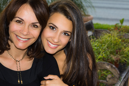 Mother and daughter in a affectionate pose outdoors.の写真素材