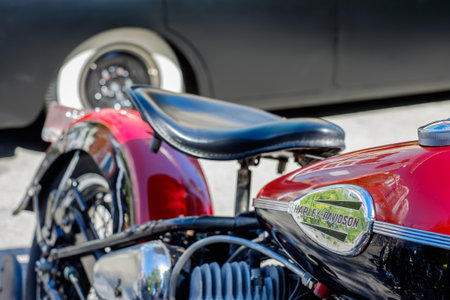 MIAMI, FLORIDA USA - APRIL 12, 2014  Close up of a vintage Harley Davidson motorcycle on display at the Old Soul Young Blood Vintage Motorcycle festival with a classic American automobile in the background のeditorial素材
