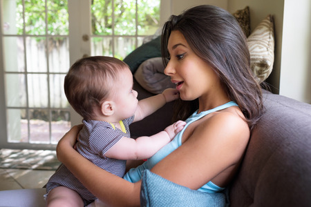 Cute baby boy with pretty young woman in a home setting 
